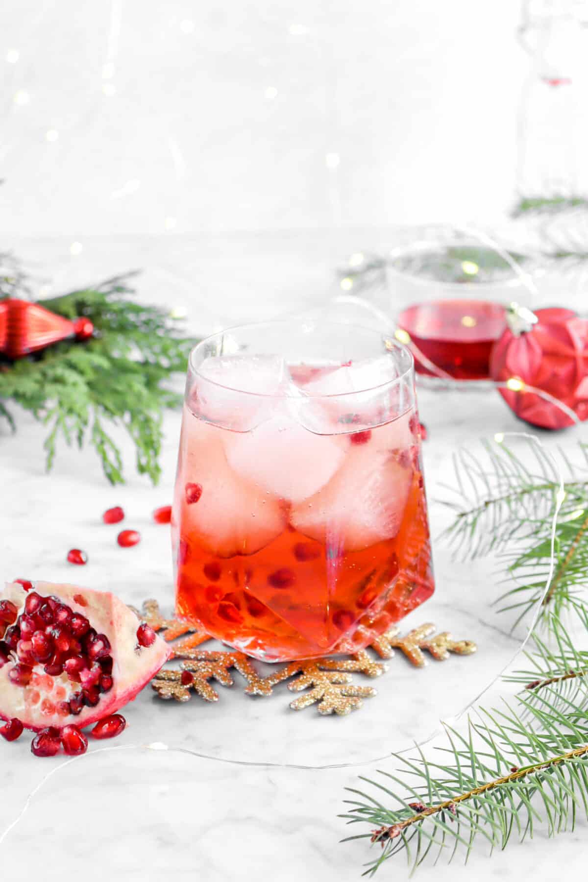 Pomegranate moscow mule with ornaments, greenery, fairy lights, and pomegranate wedge