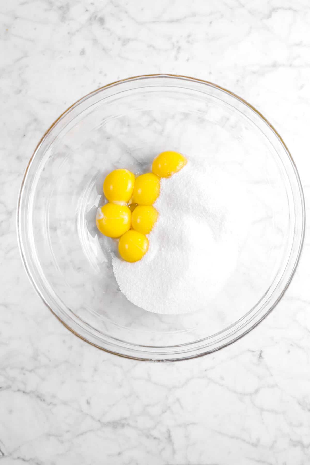 egg yolks and sugar in glass bowl