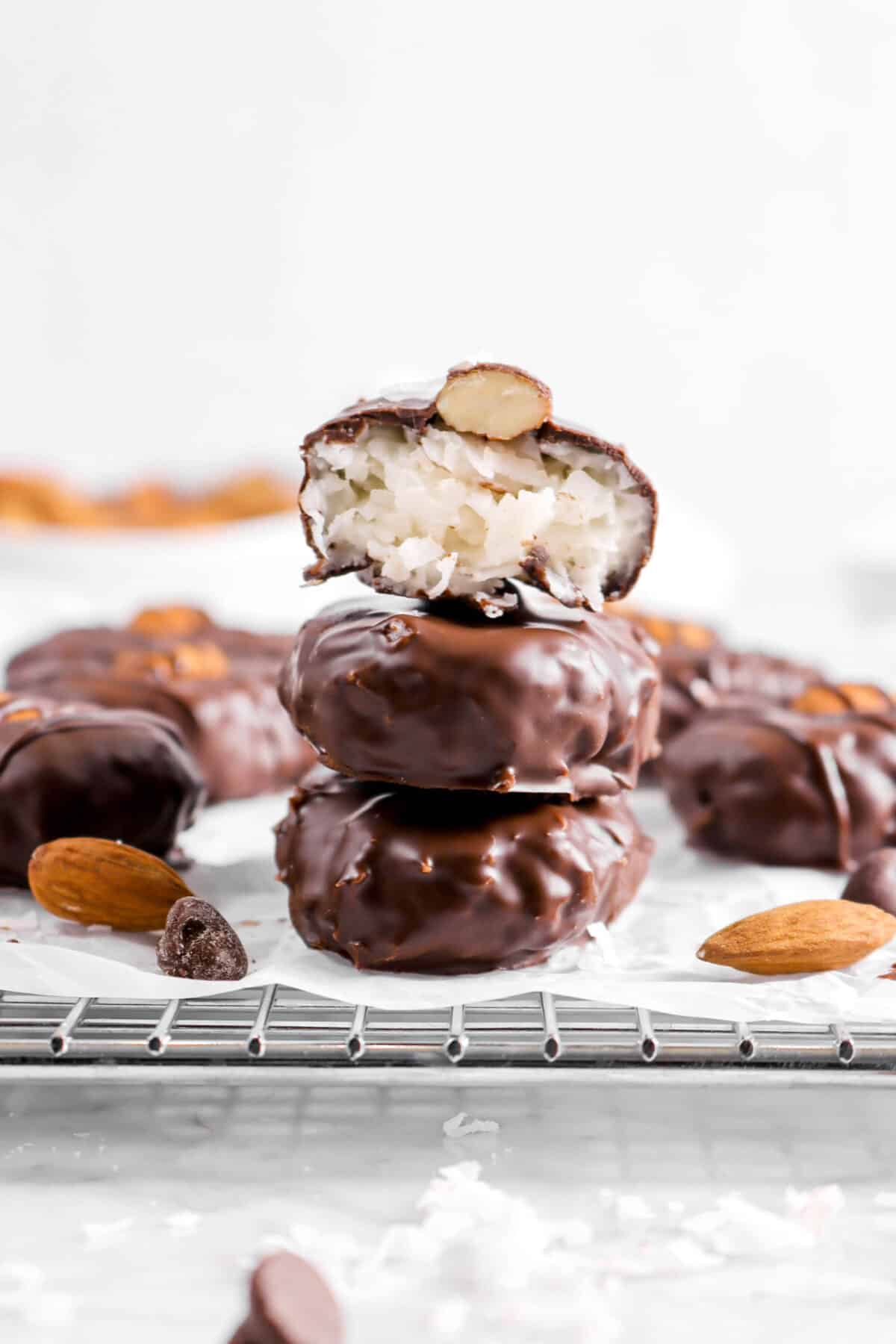 close up of three stacked almond joys with one cut in half with more around