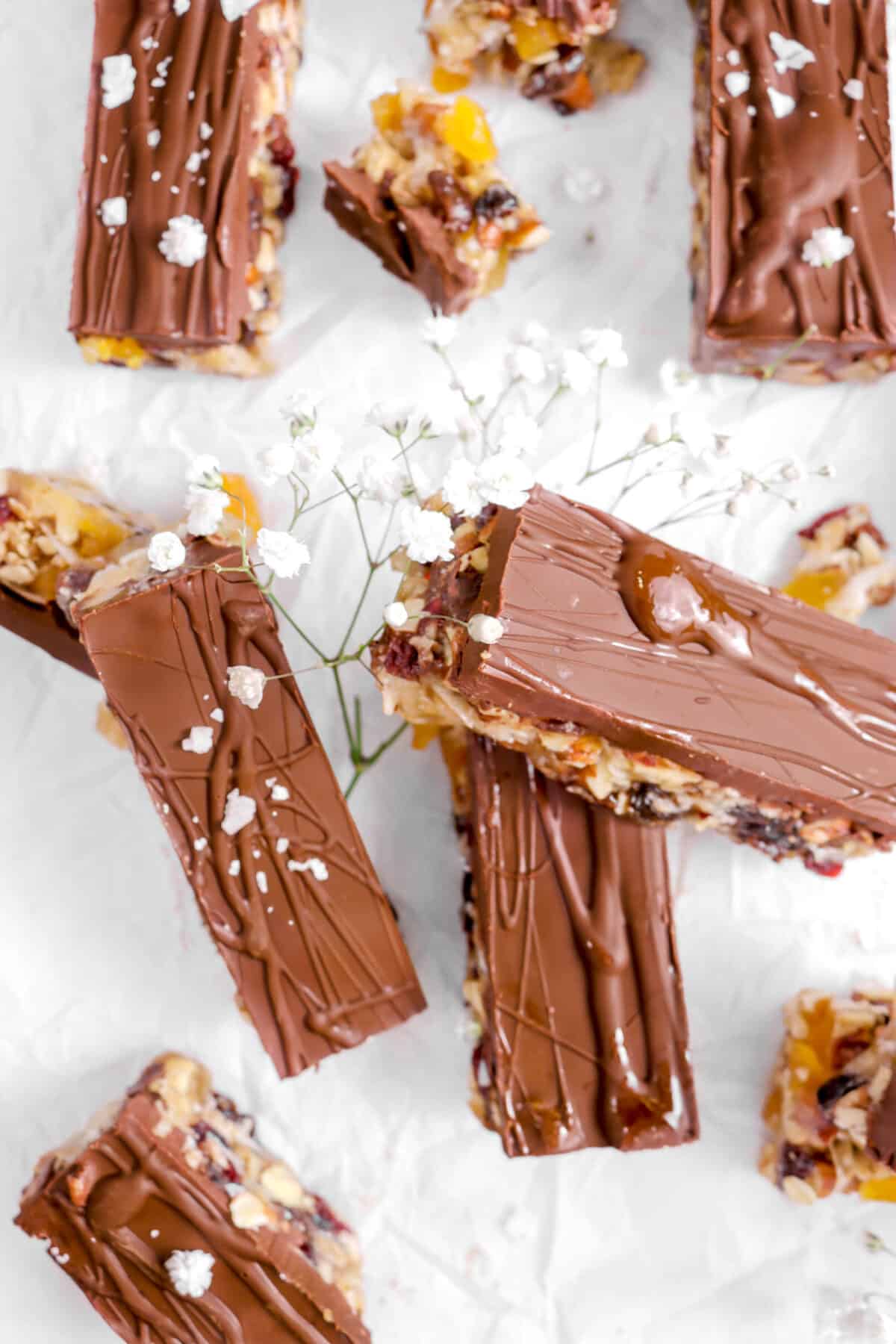 six granola bars on parchment with flaked salt and flowers