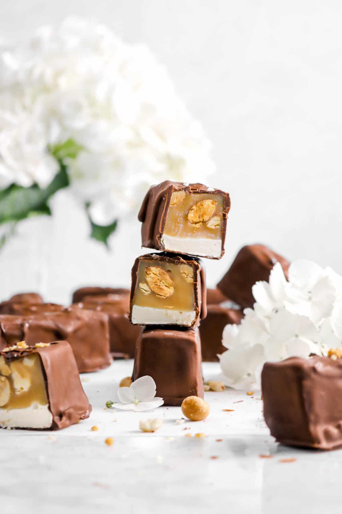three stacked snickers with more around and hydrangeas behind