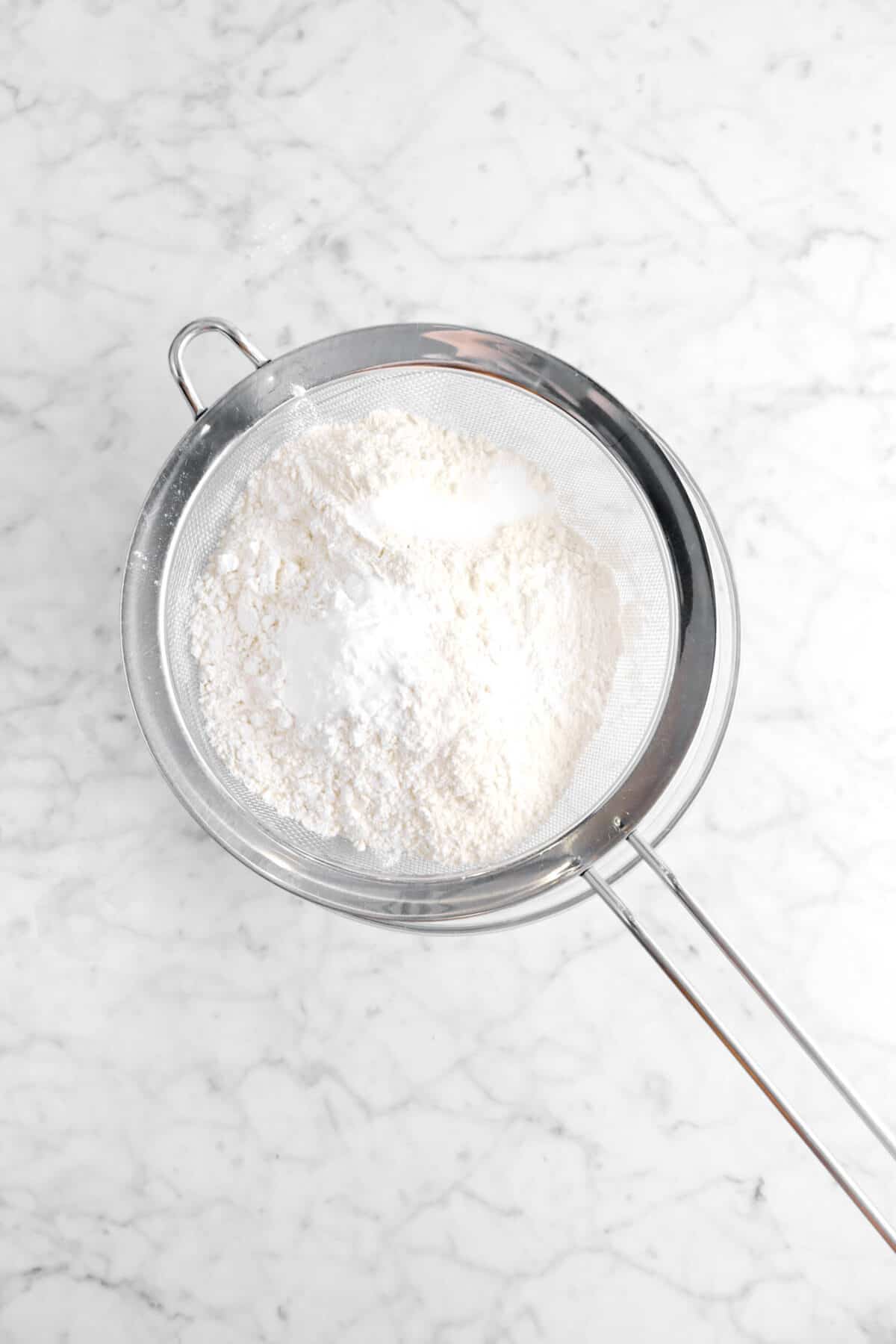 flour, baking powder, baking soda, and salt in a sieve