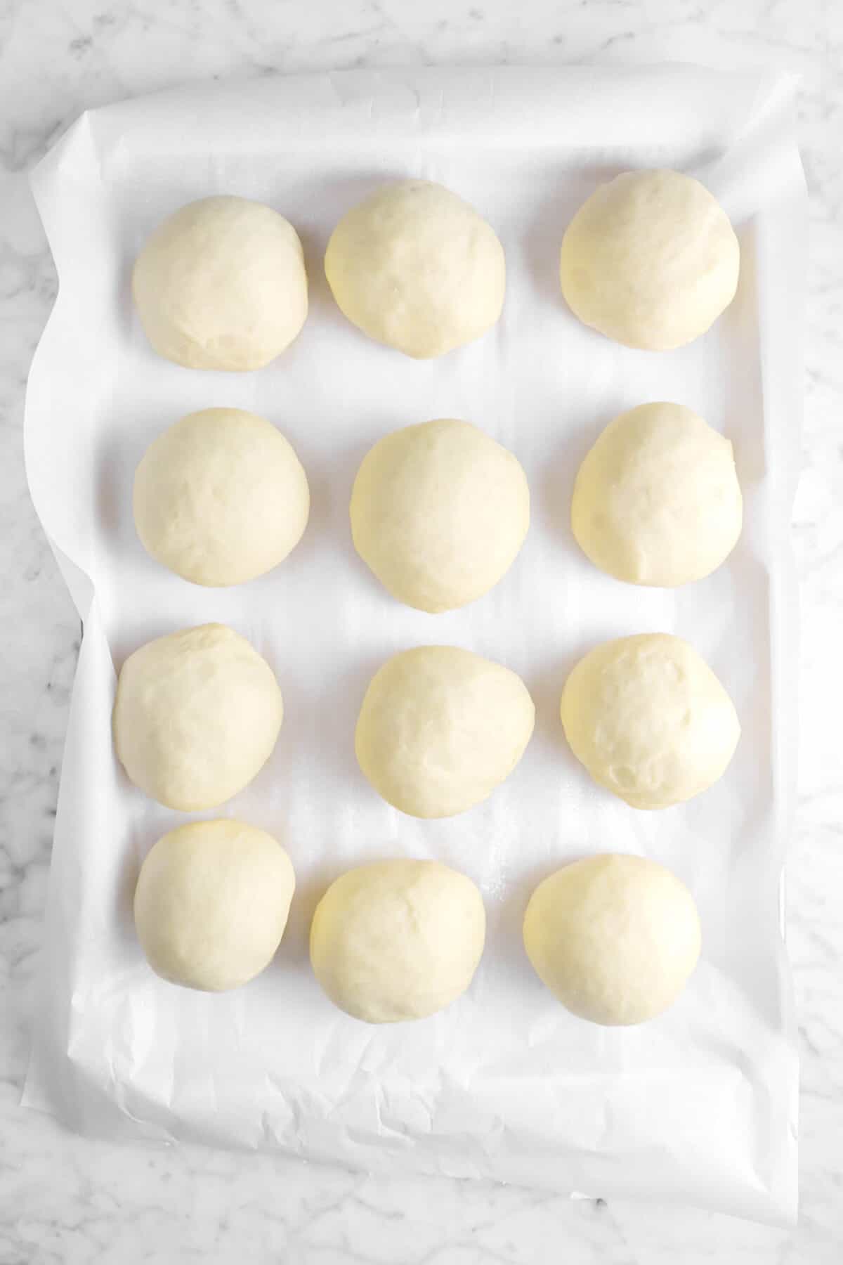 twelve dough balls on parchment paper