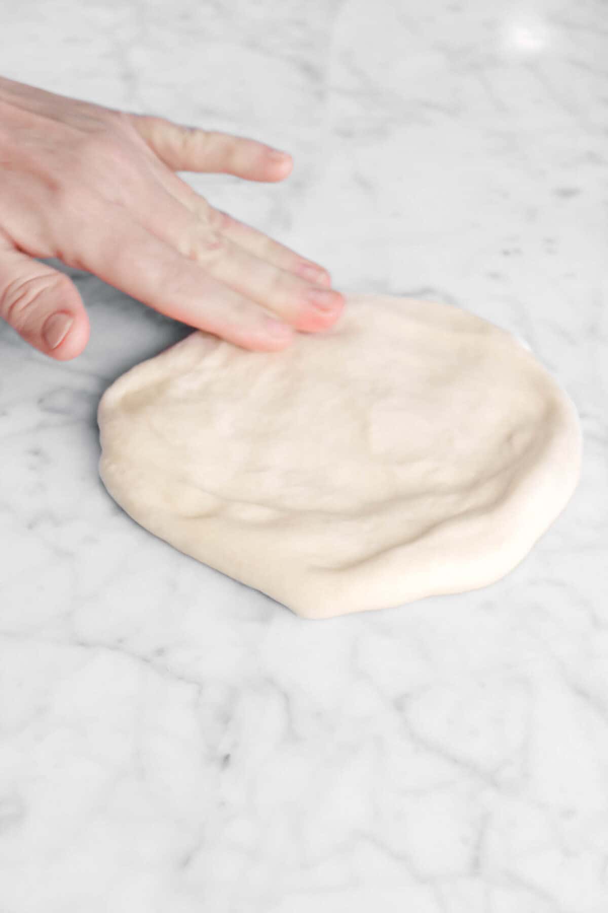 naan being pressed out on marble counter