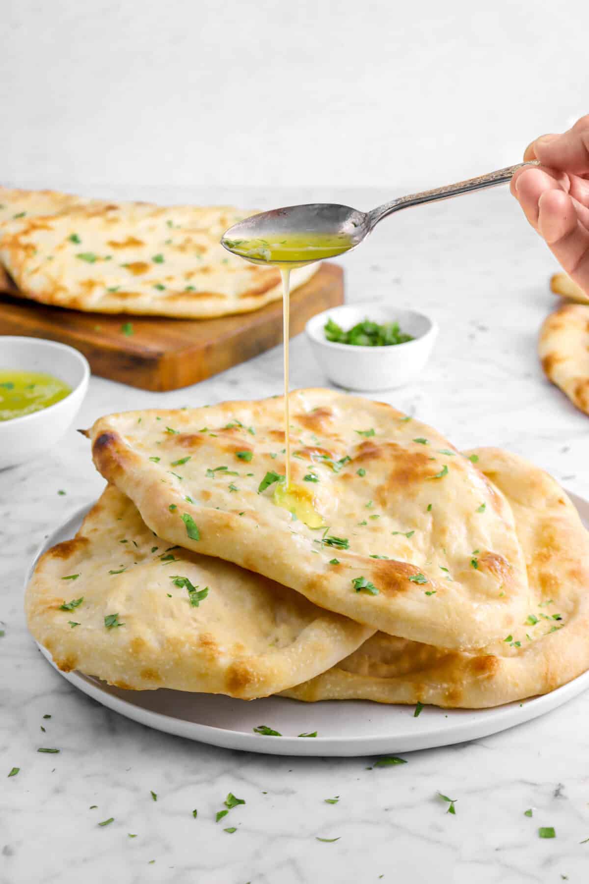 butter being poured onto naan with spoon