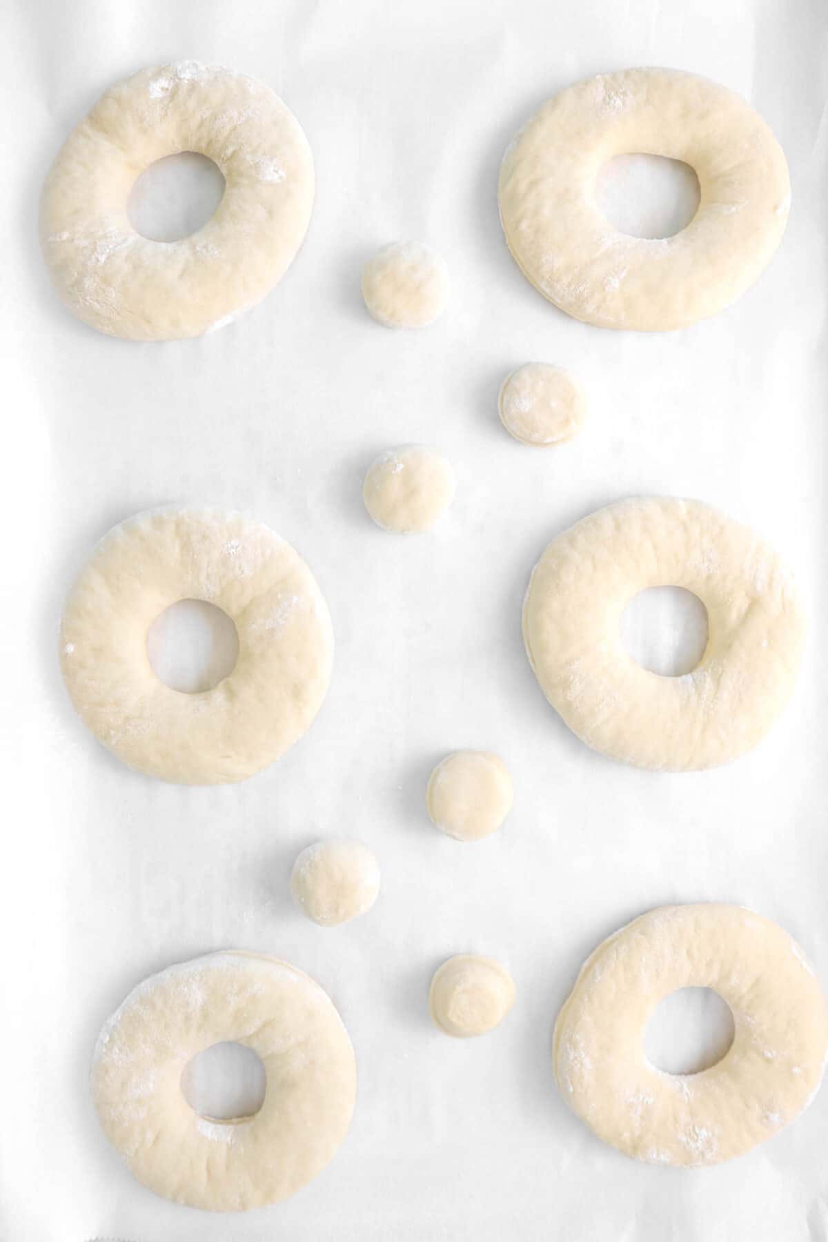 six doughnuts on parchment paper with six doughnut holes