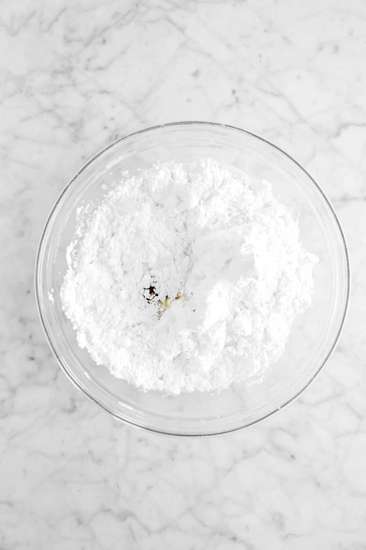 powdered sugar, vanilla, and milk in glass bowl