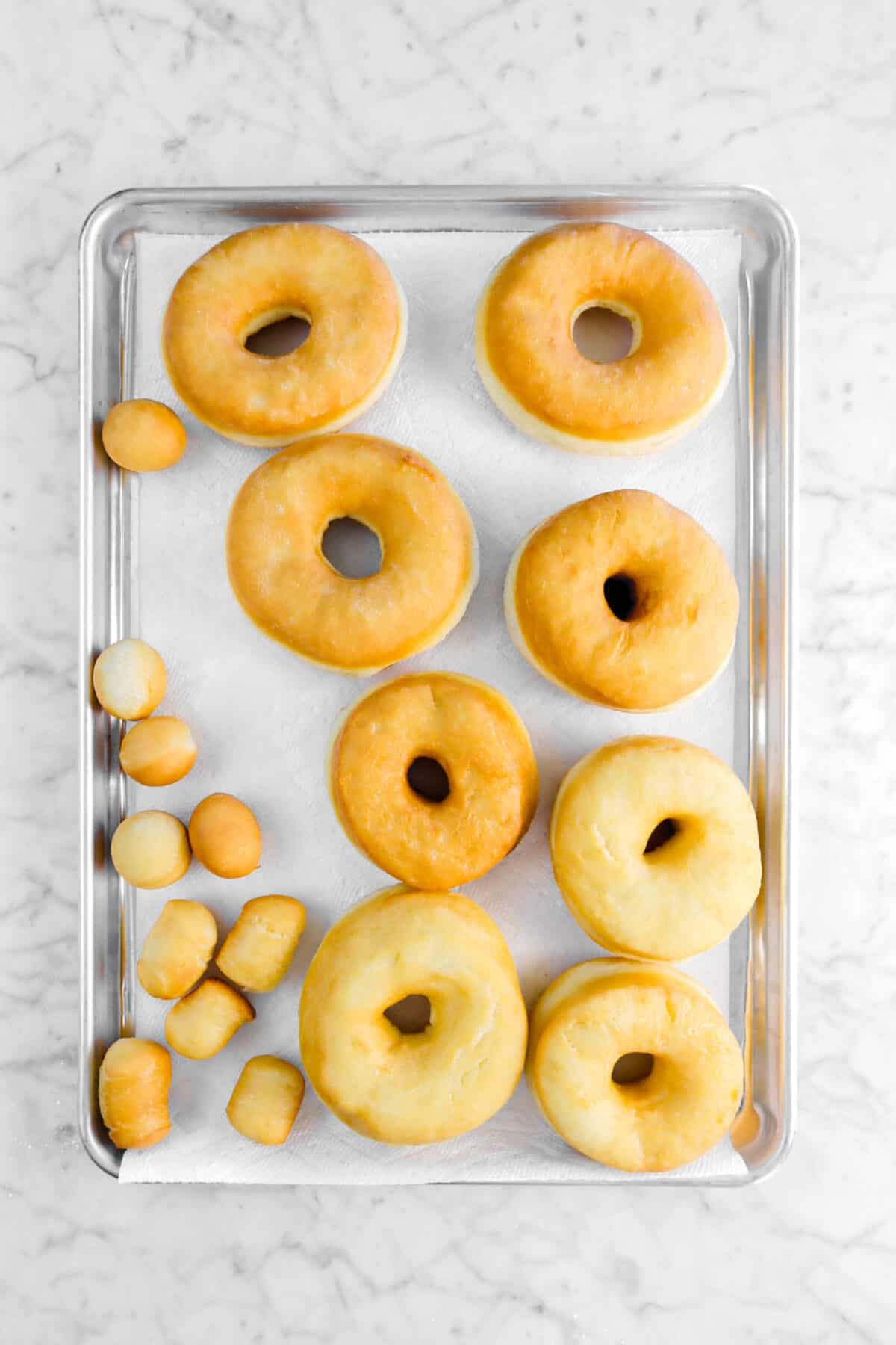 fried doughnuts on sheet pan with paper towels