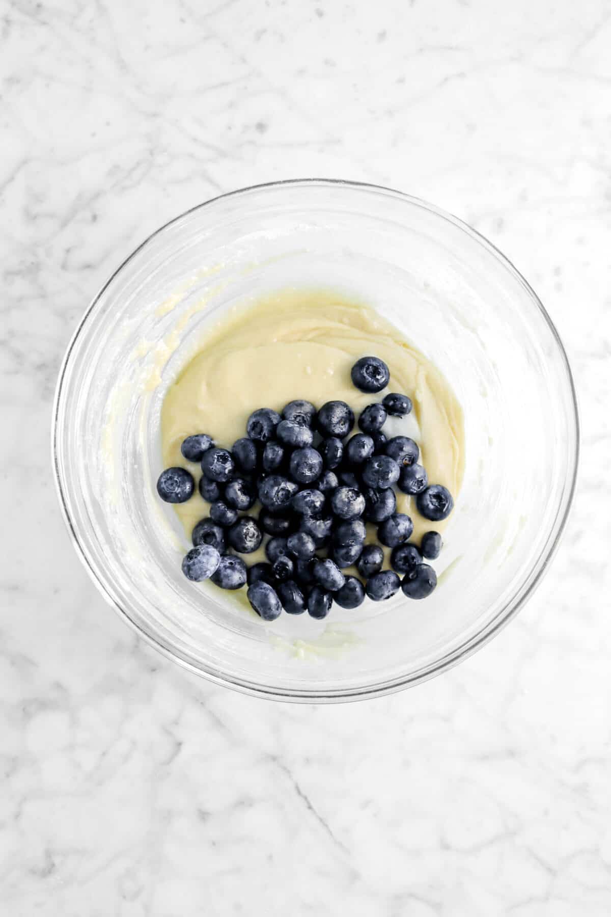 blueberries in glass bowl with muffin batter
