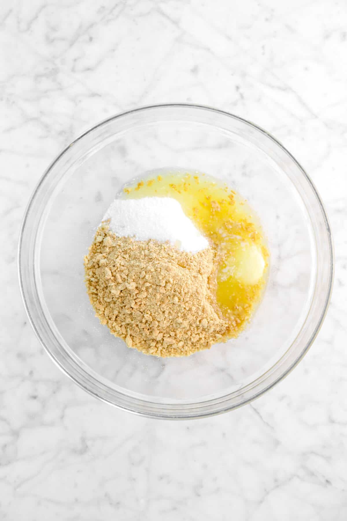 melted butter, sugar, and graham cracker crumbles in glass bowl