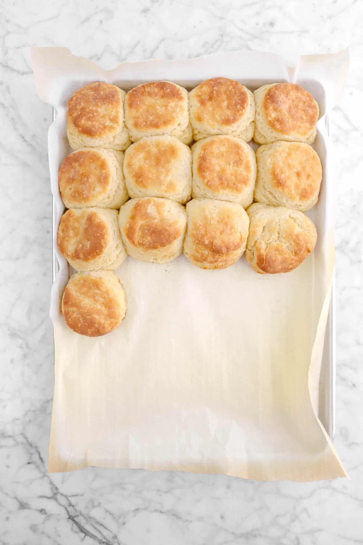 baked biscuits in a lined sheet pan