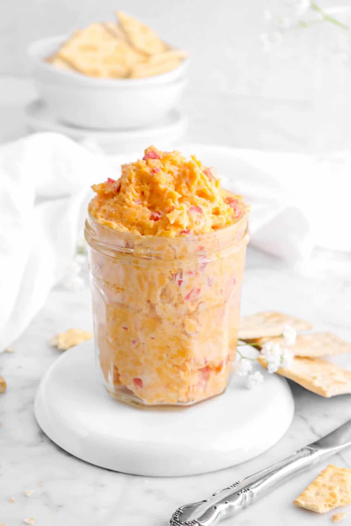 close up of pimento cheese on white plate with crackers