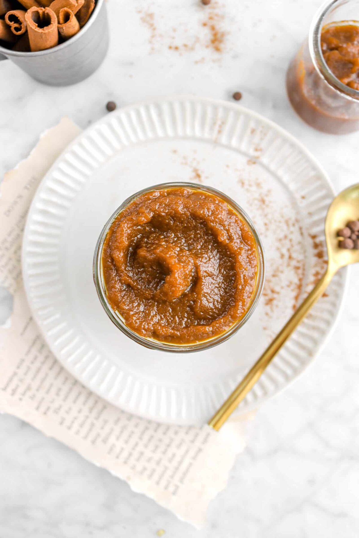 overhead shot of pumpkin butter on plate with gold spoon