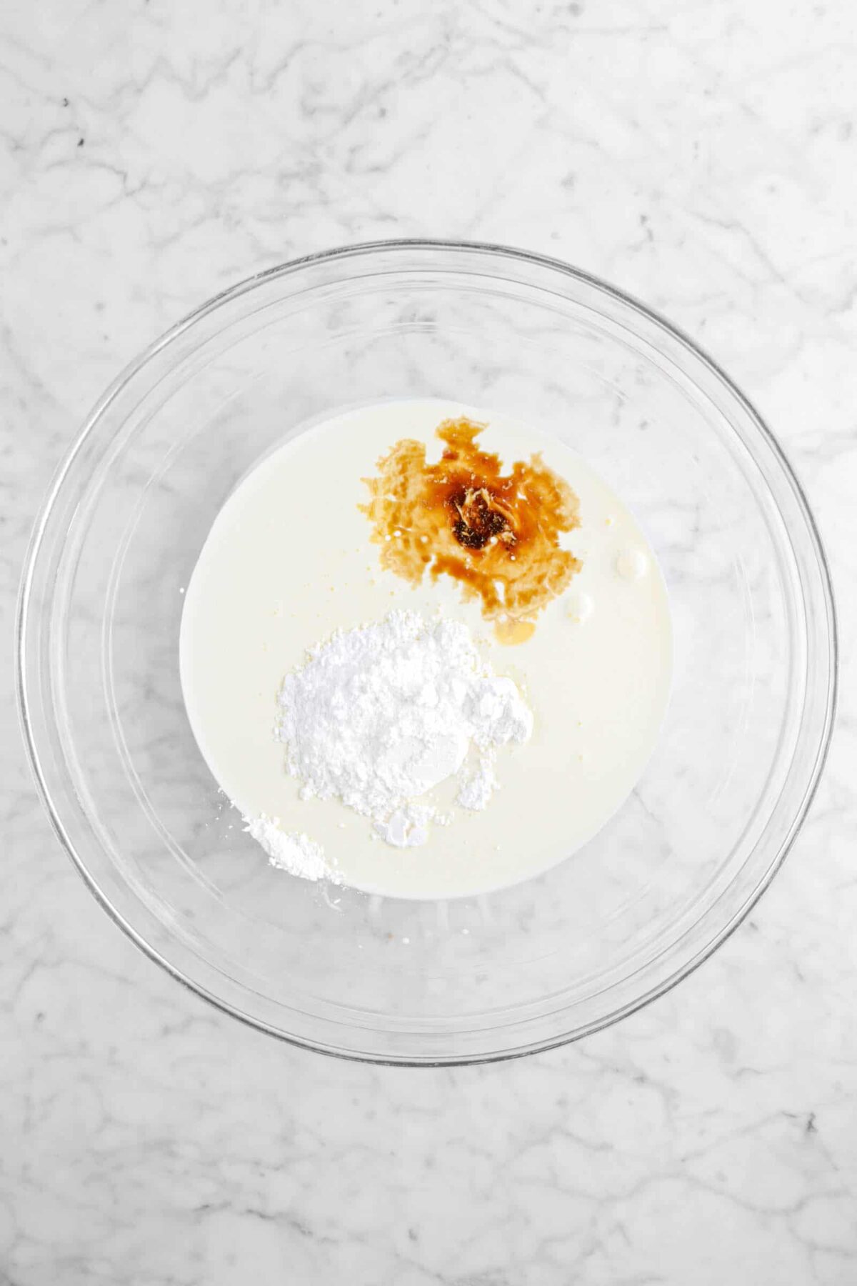 vanilla, heavy cream, and powdered sugar in glass bowl