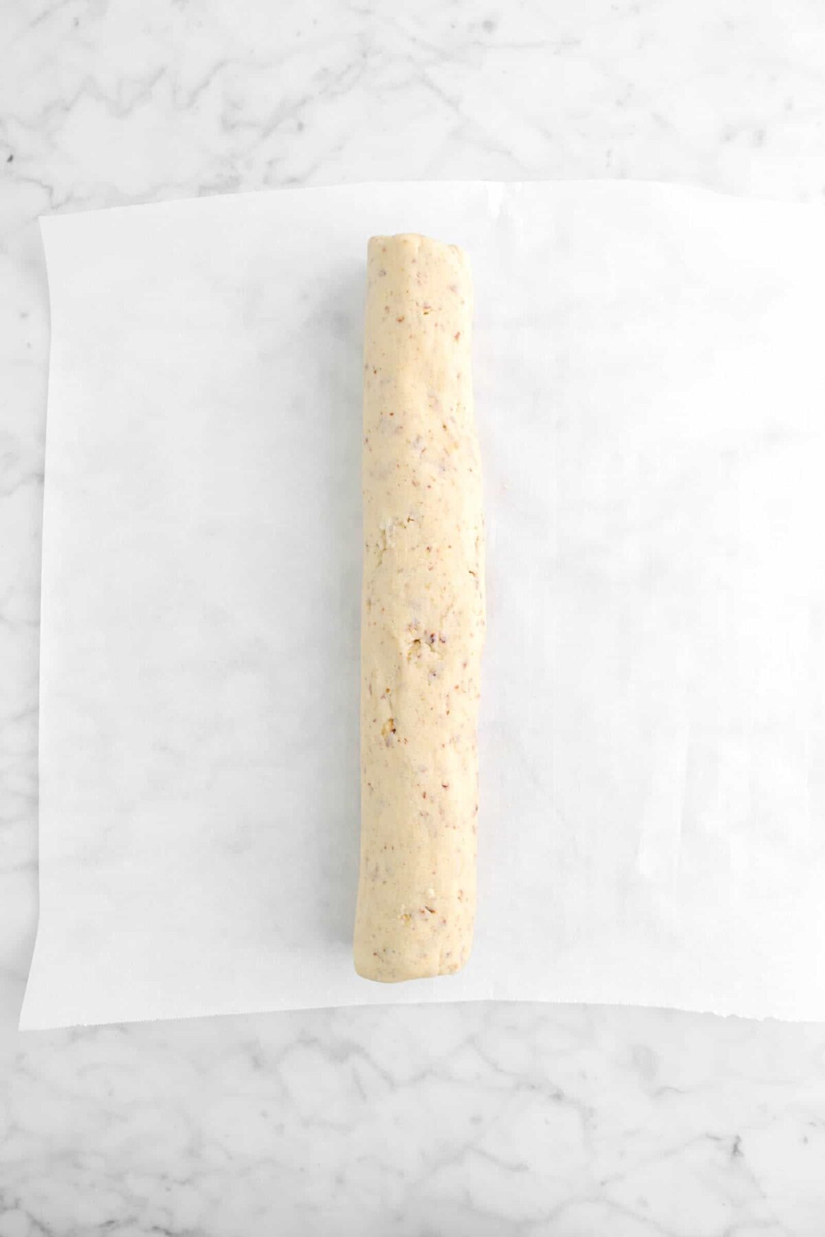cookie dough rolled into a log on parchment paper