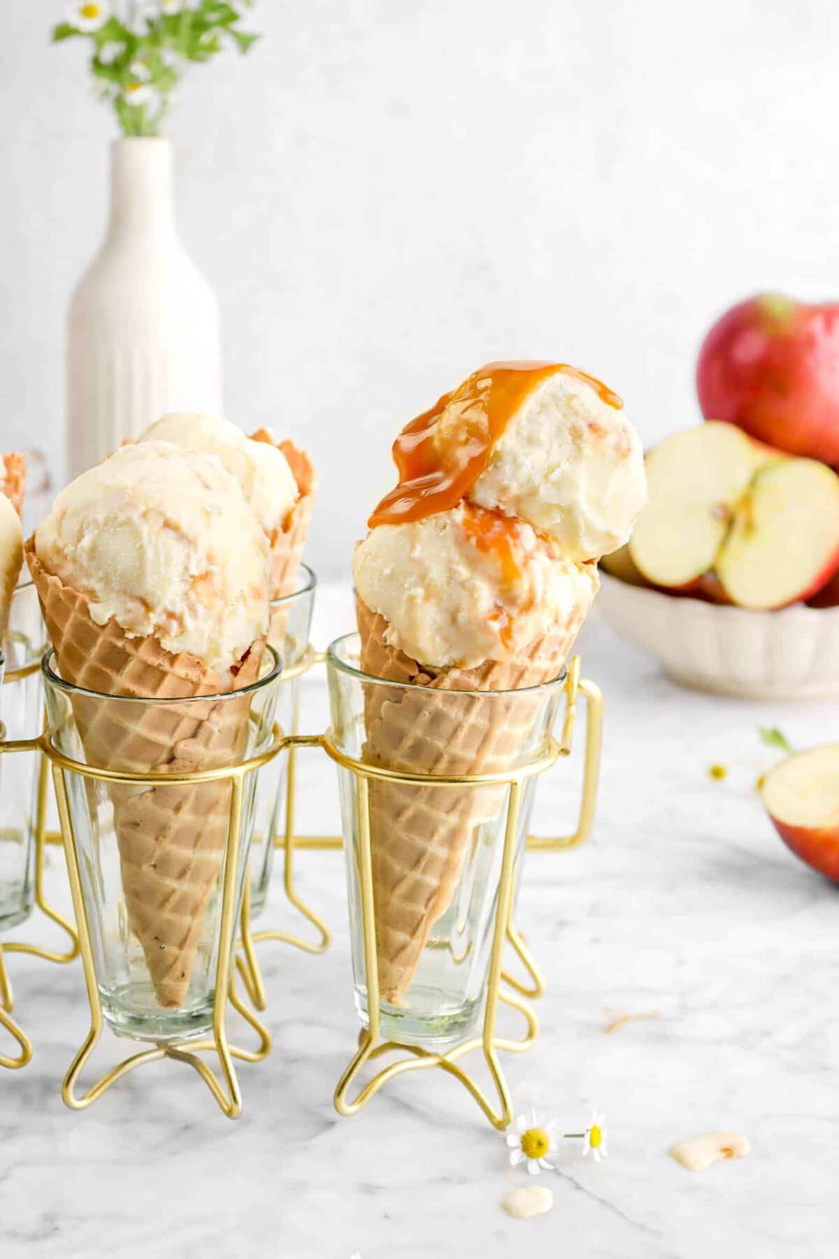 caramel on top of ice cream in drink caddy with apples behind