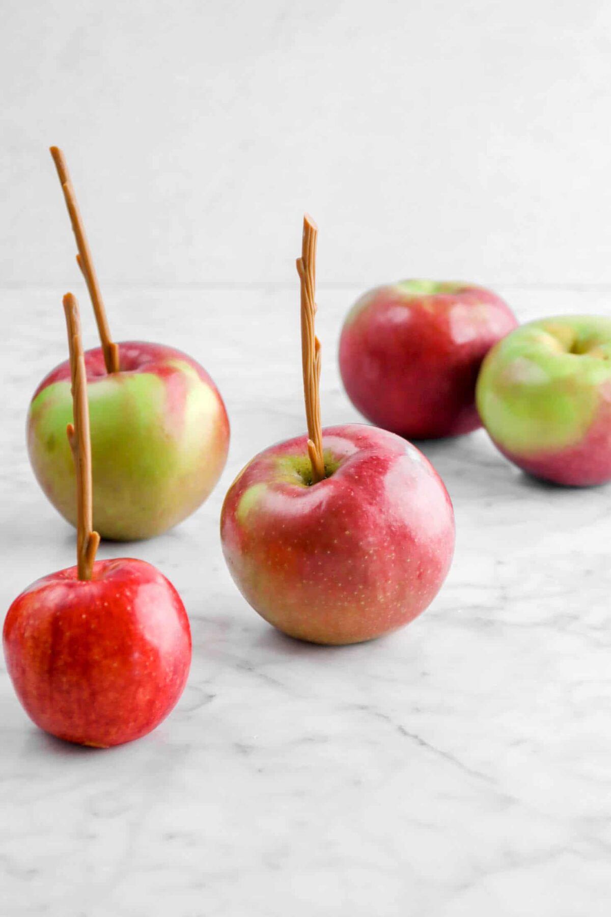 apples on marble counter with sticks in them