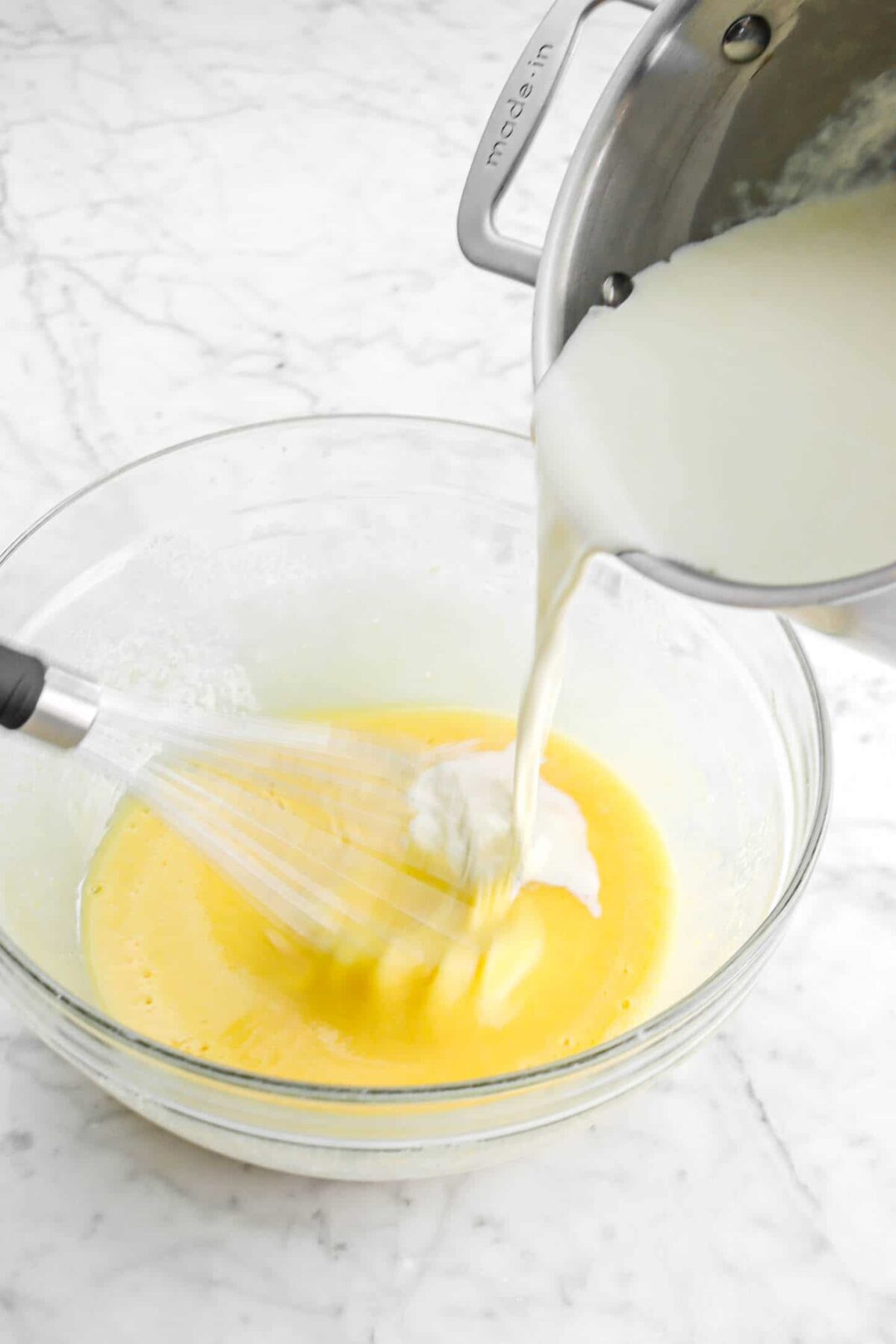 heavy cream being poured into egg mixture