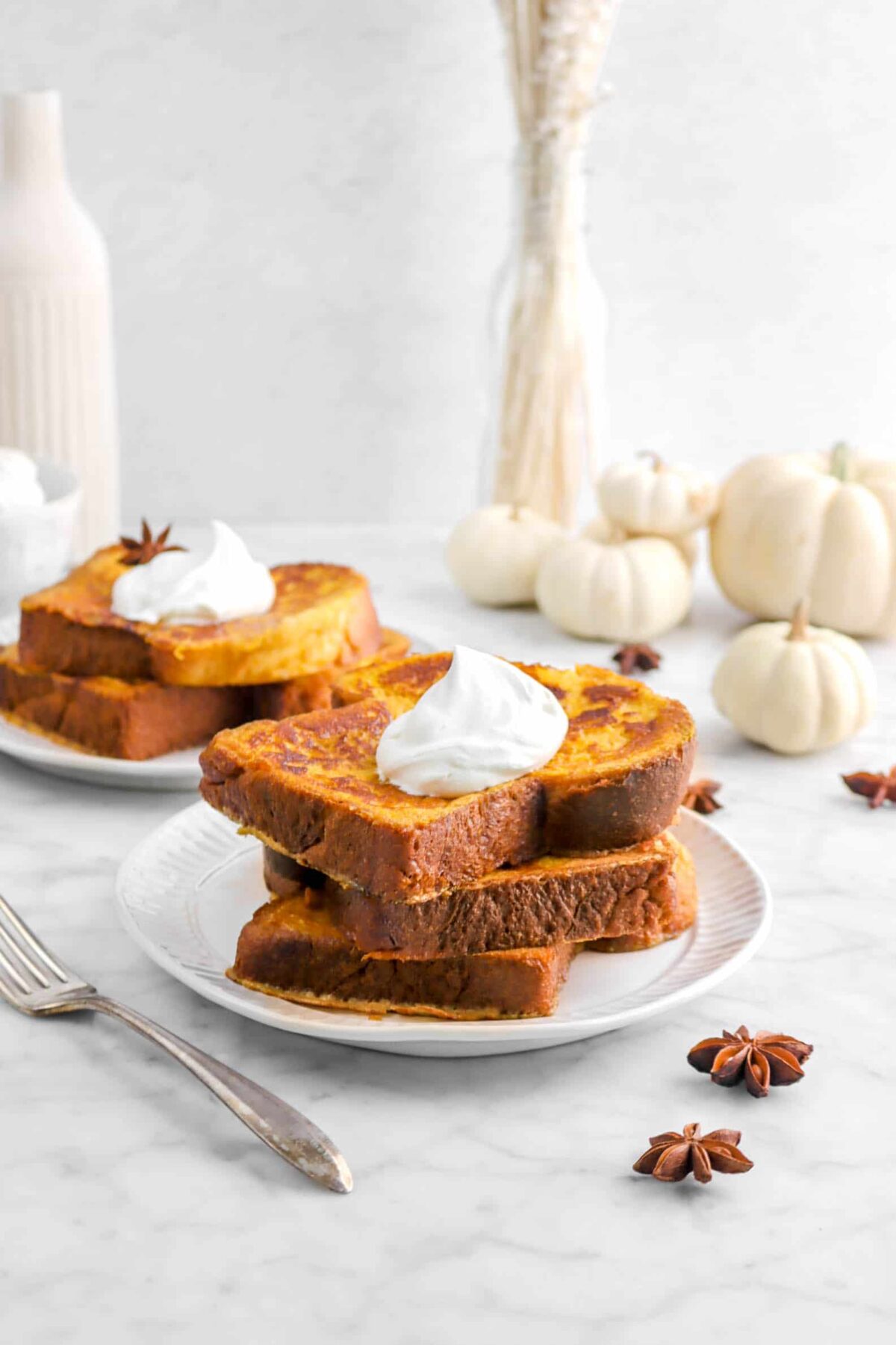 three stacked french toast with pumpkins behind