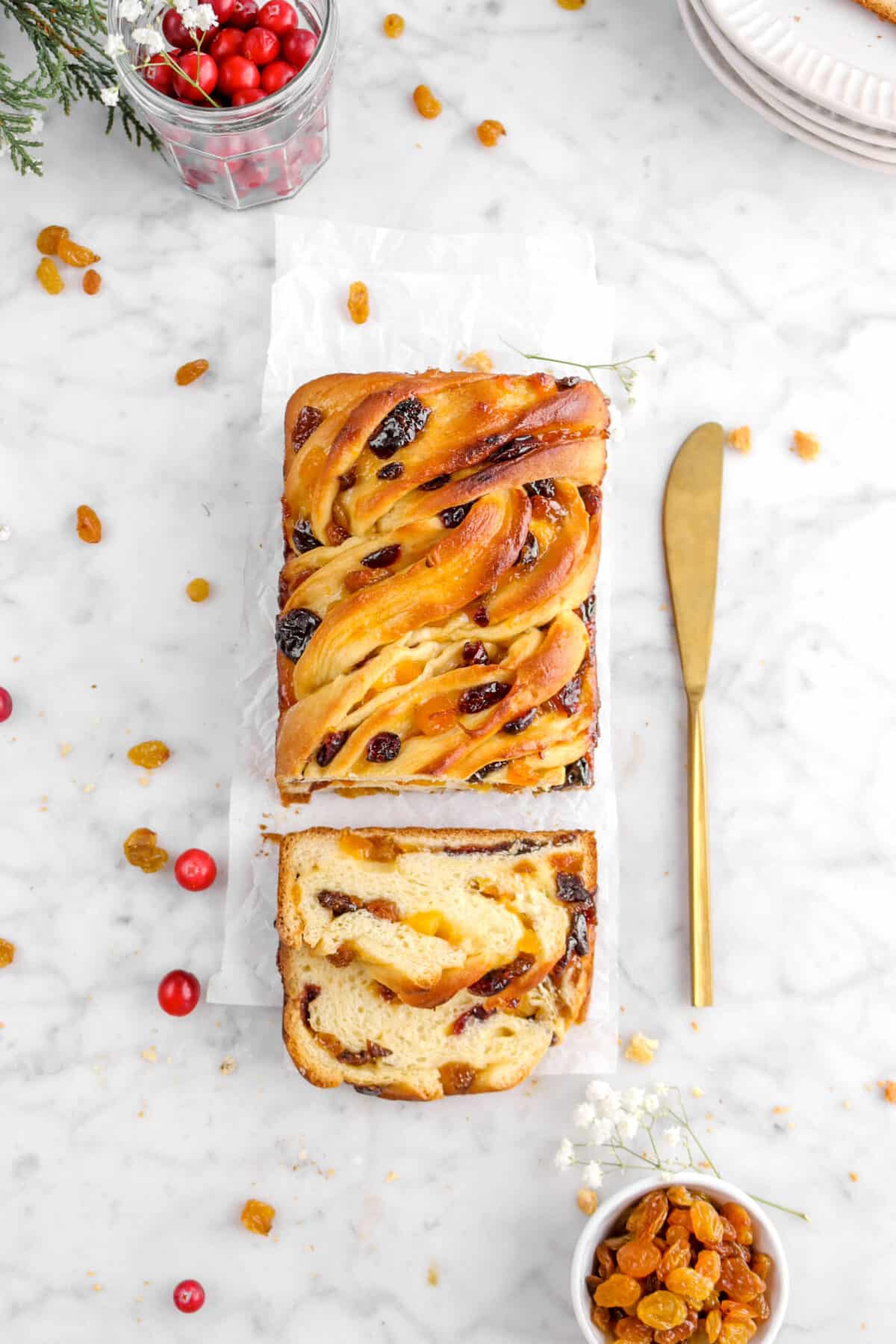 overhead photo of apricot babka on parchment paper with gold knife
