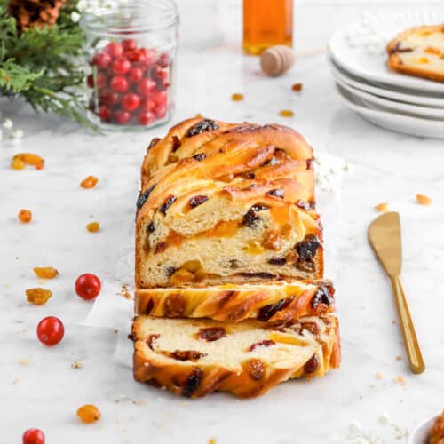 apricot babka with fresh cranberries, gold knife, and two slices laying in front