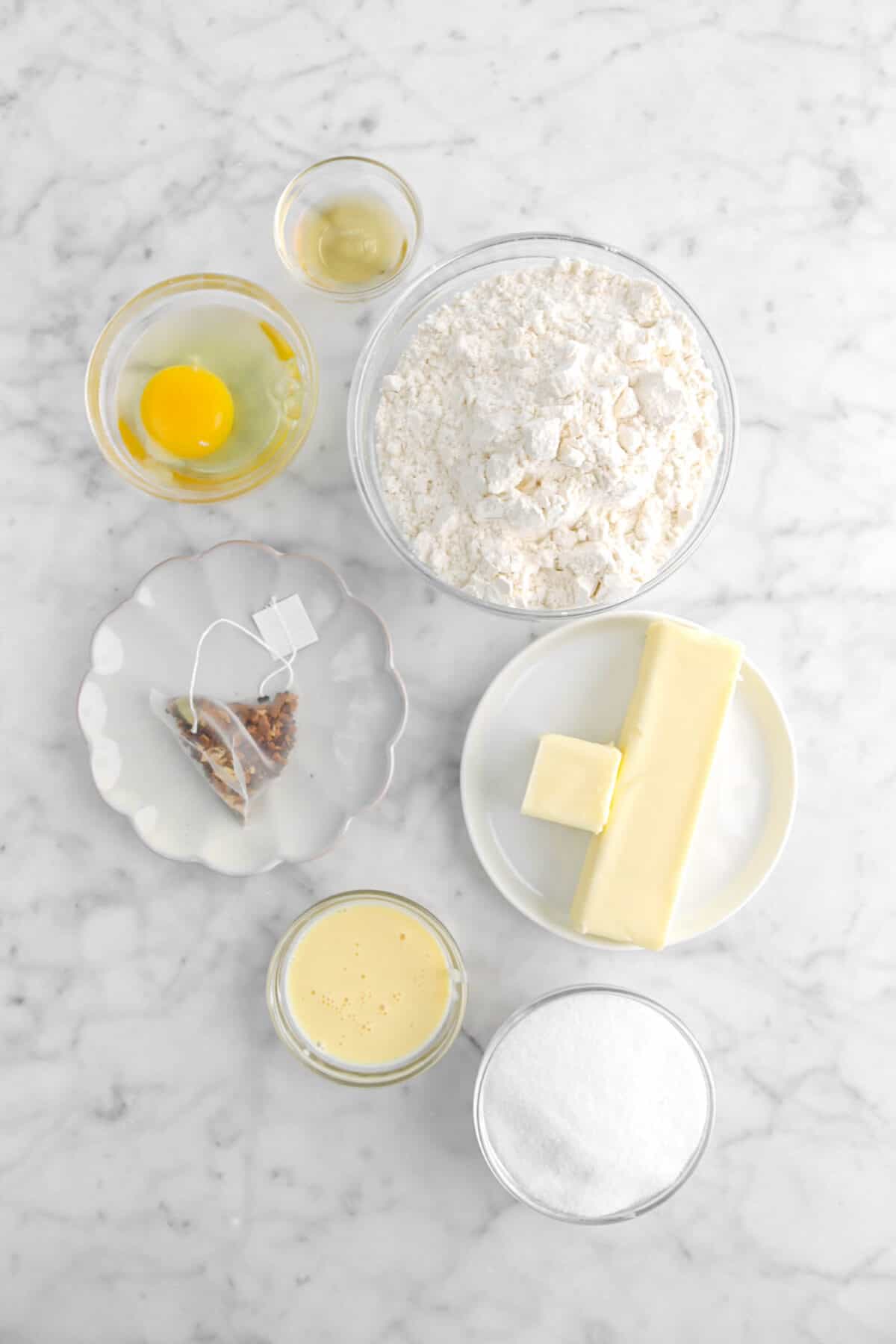 bourbon, egg, flour, chai tea bag, butter, eggnog, and sugar on marble counter