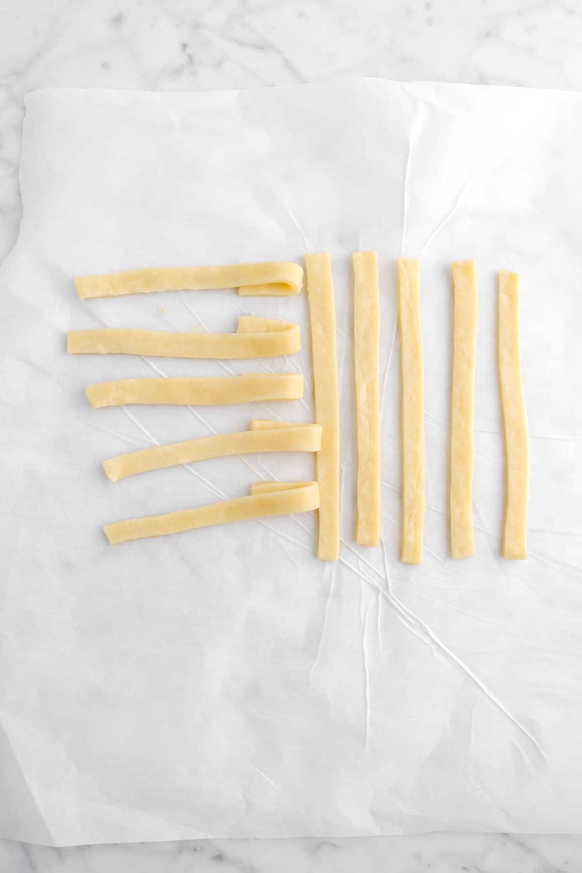 five strips of pie dough laying vertically and five strips laying horizontally, folded over themselves