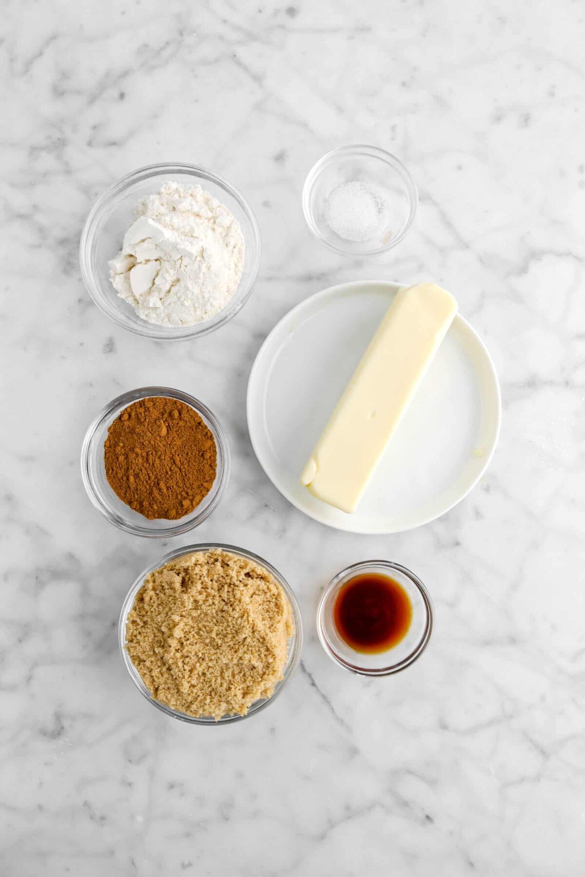 salt, flour, pumpkin pie spice, brown sugar, vanilla, and butter on marble counter