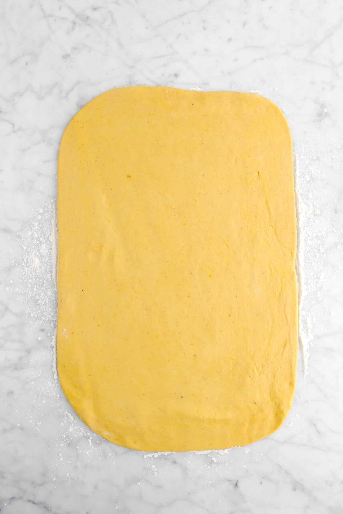 pumpkin dough rolled out on marble counter