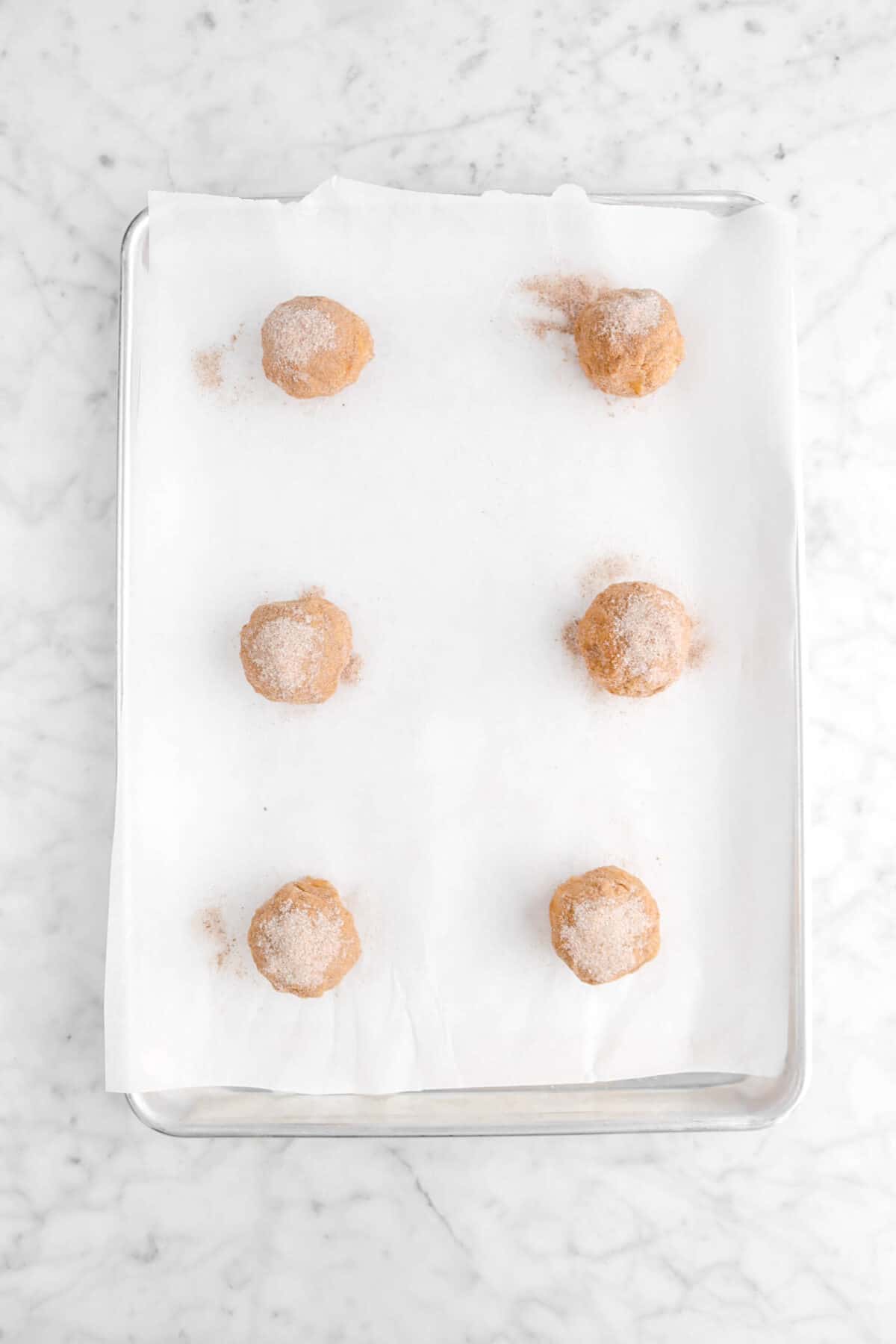 six cookie dough balls on lined parchment