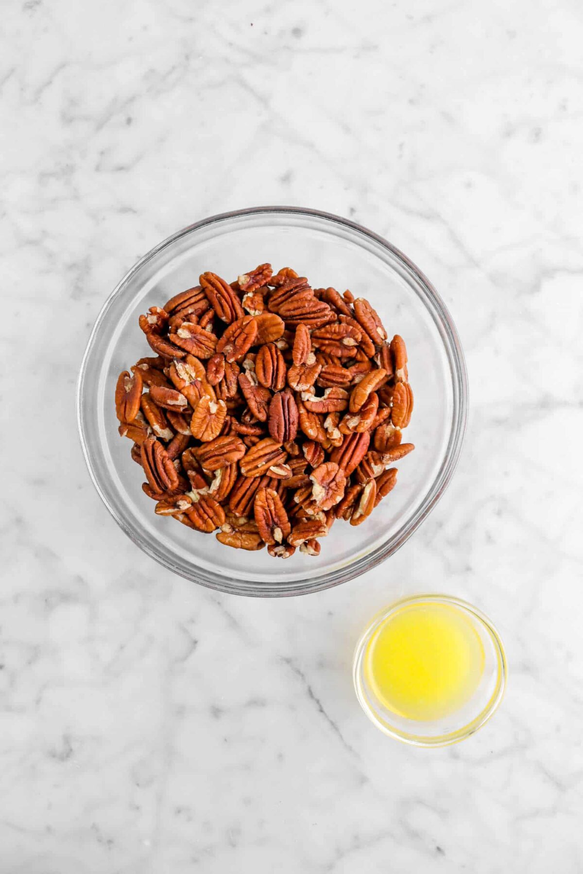 pecans and butter in two bowls on marble counter