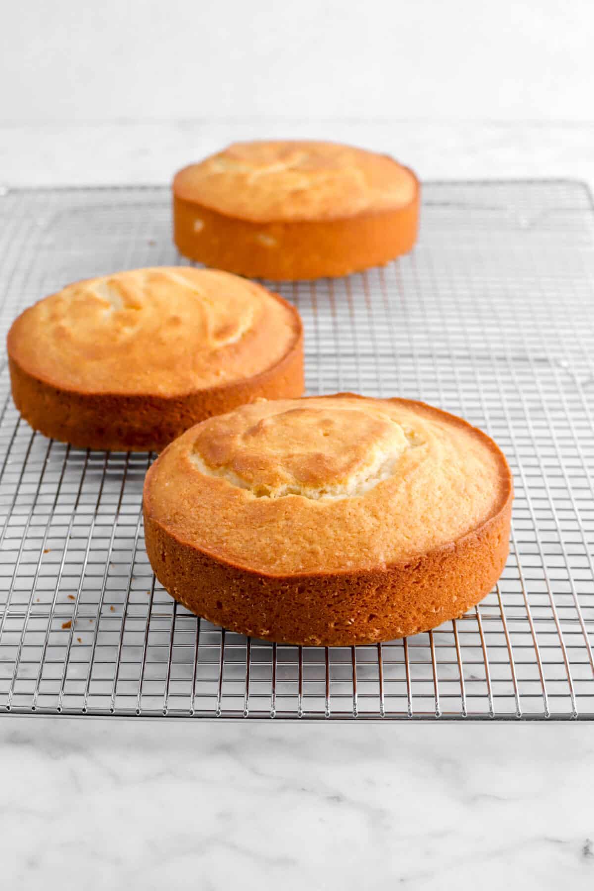 three round cakes on wire cooling rack