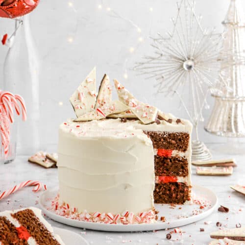 chocolate peppermint cake on white plat with slice on white plate in front of cake