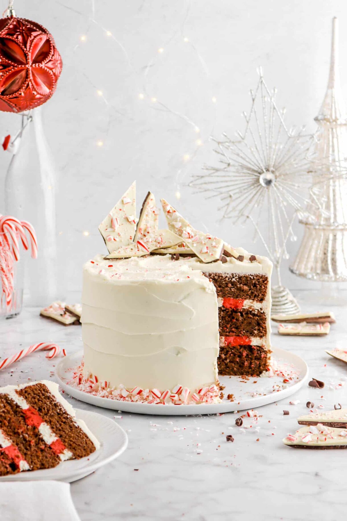 chocolate peppermint cake on white plat with slice on white plate in front of cake