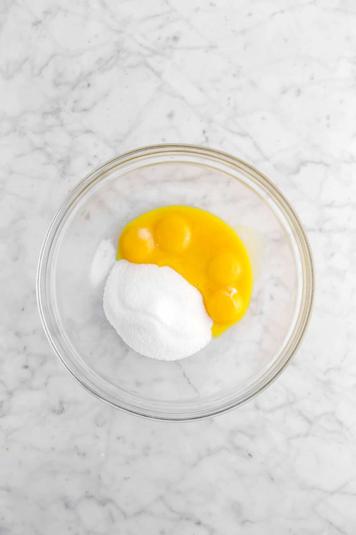 egg yolks and sugar in glass bowl
