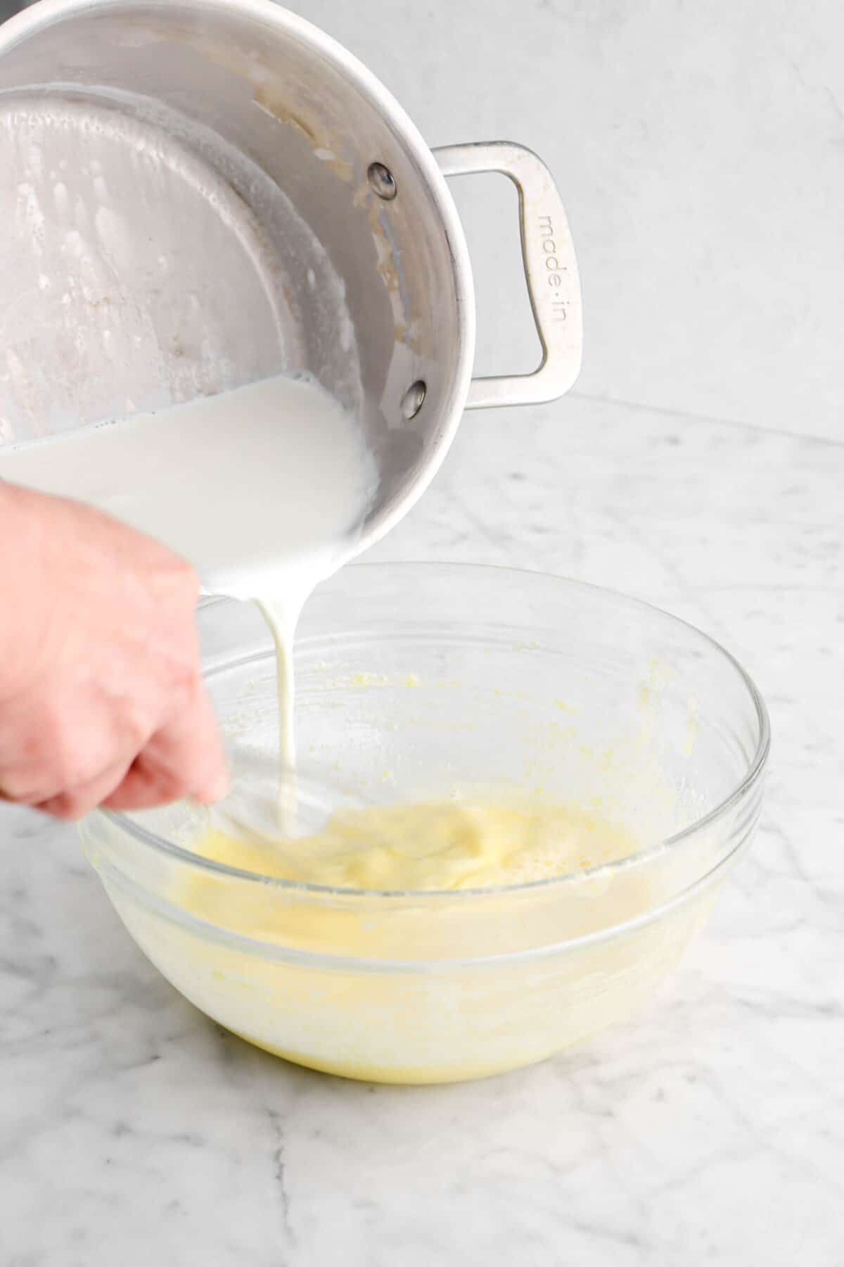 heated cream being poured into egg yolk mixture