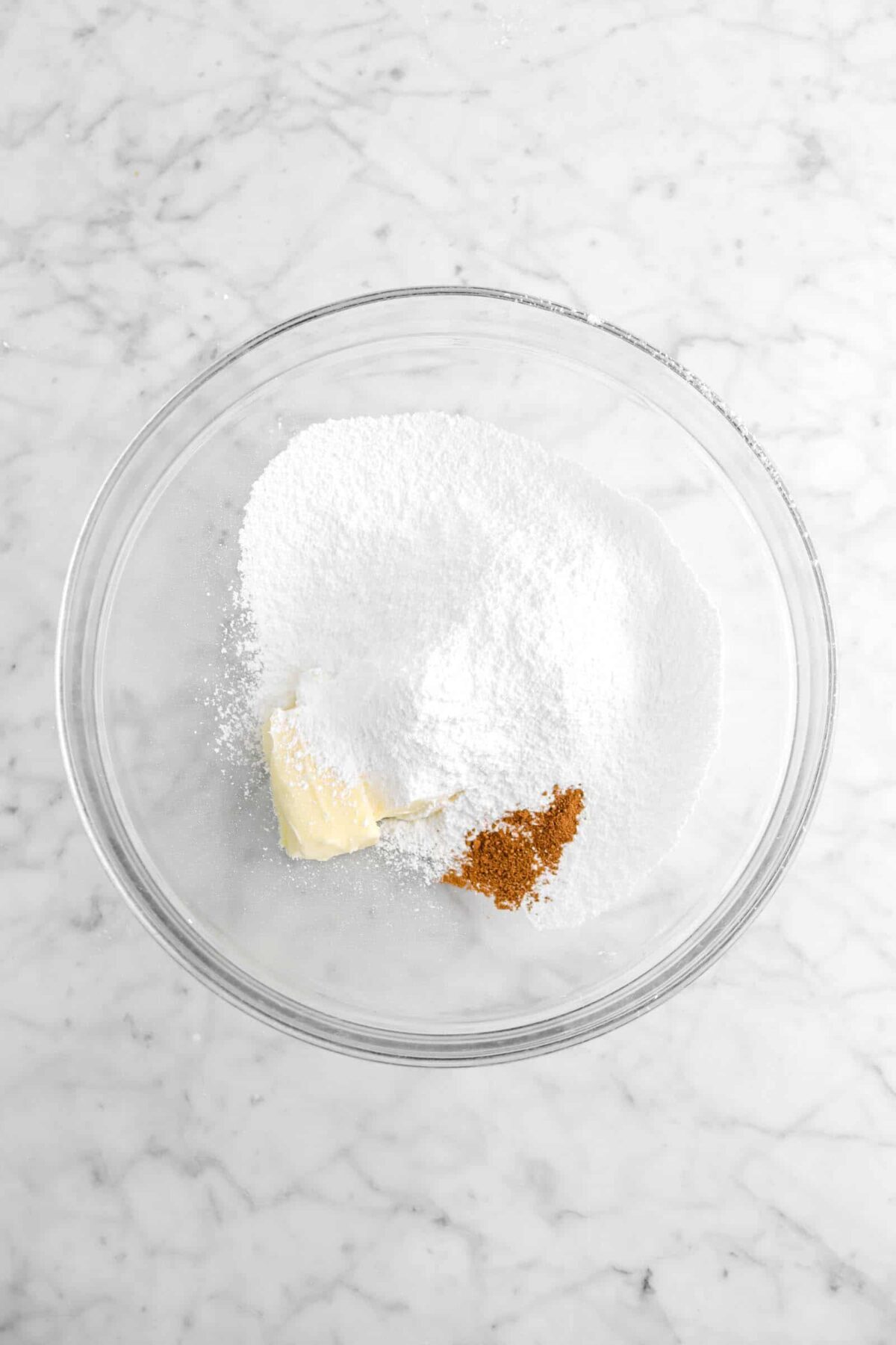 butter, powdered sugar, and gingerbread spice in glass bowl