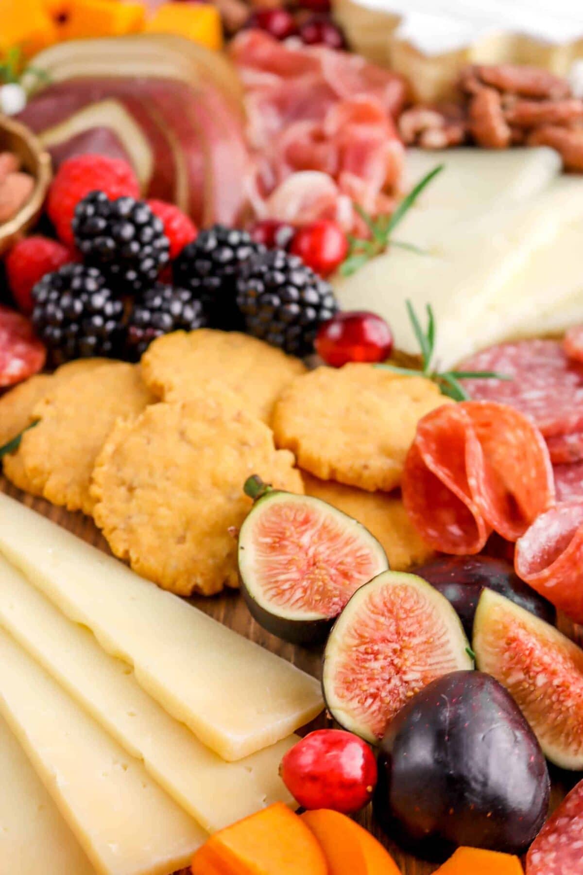 close up of figs on board with cheese, other berries, and crackers