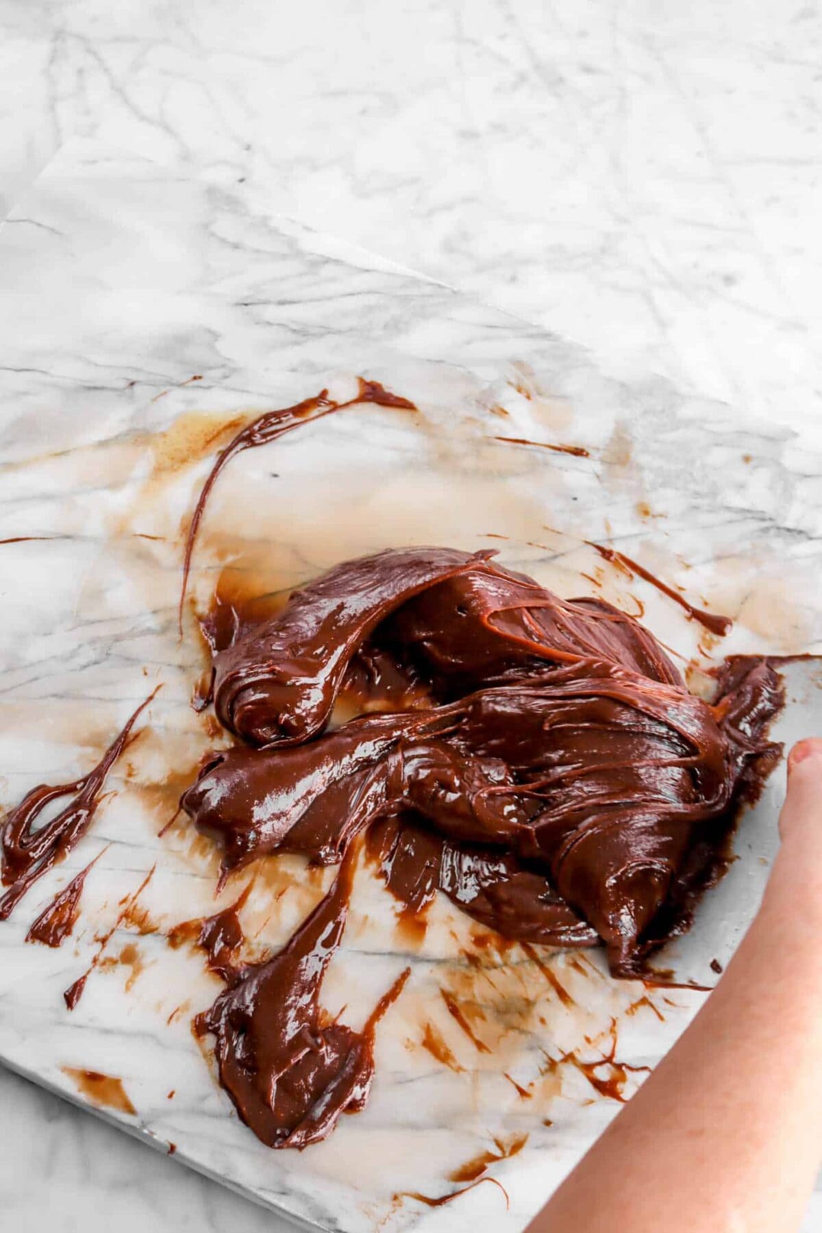chocolate being folded on marble counter