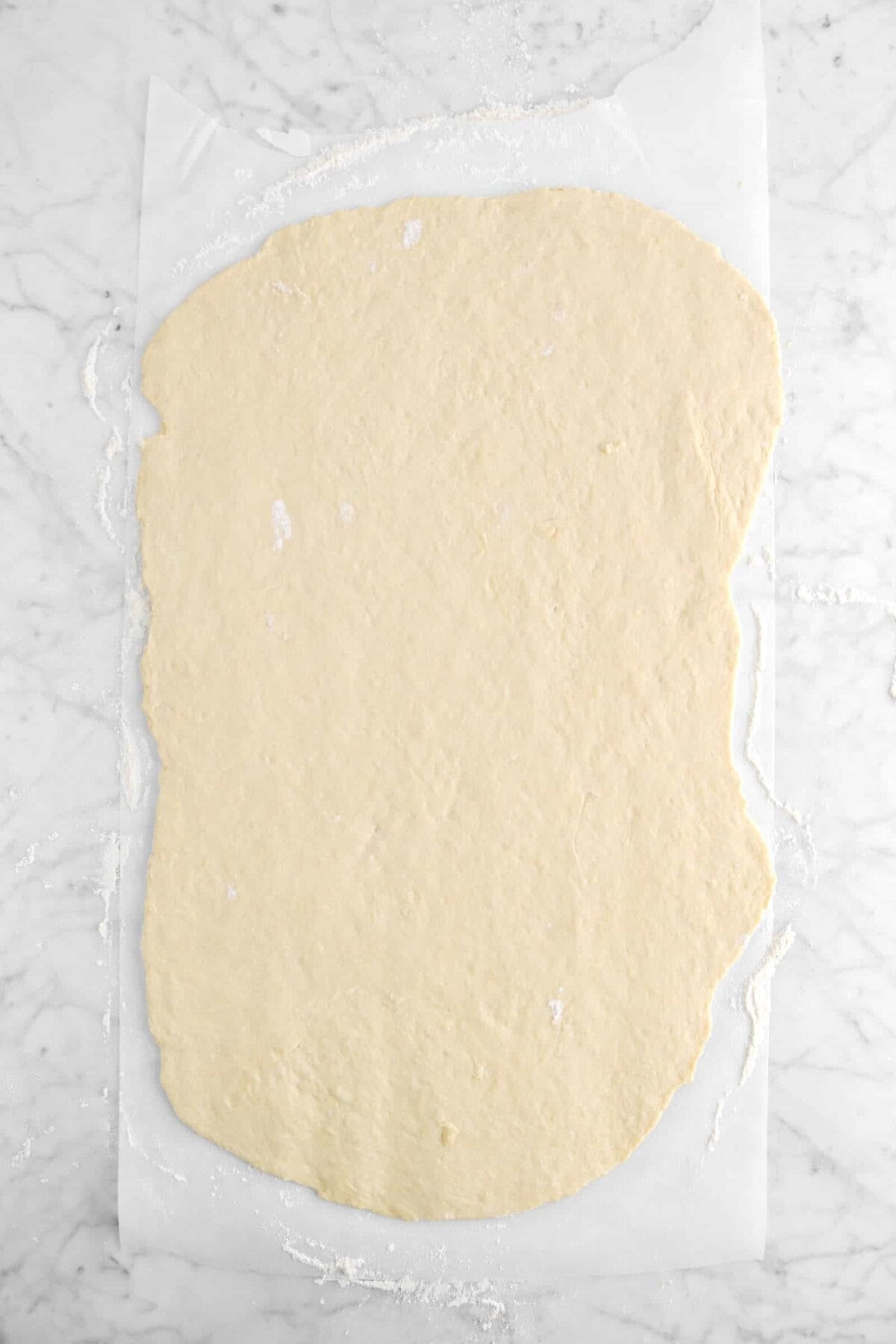 dough rolled out into a long rectangle on parchment paper