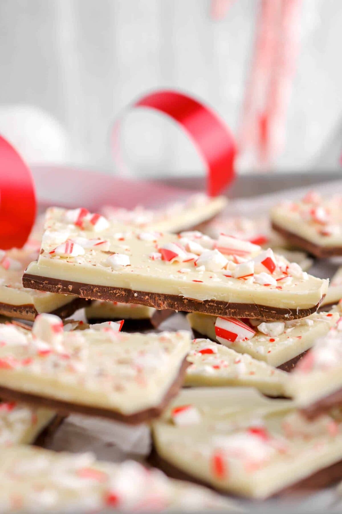 close up of peppermint bark with red ribbon behind