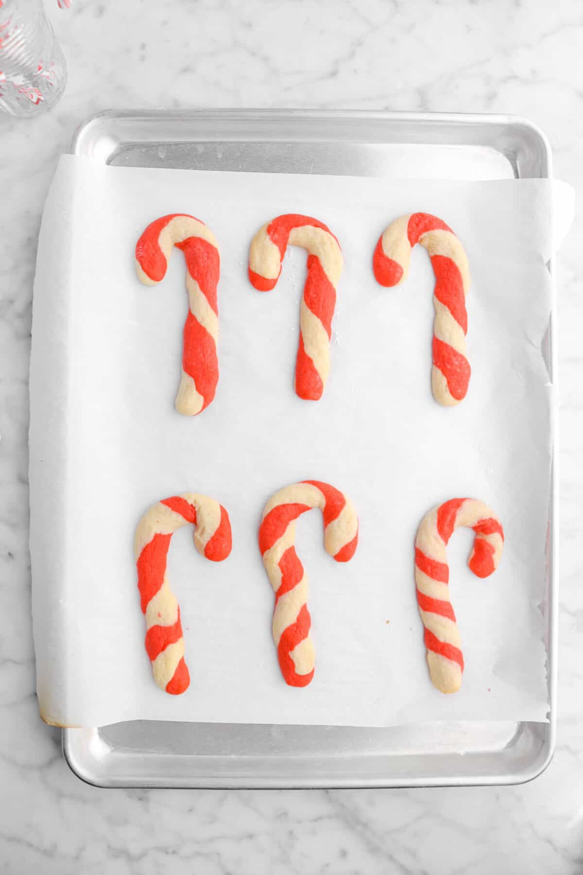 six baked candy cane cookies on sheet pan