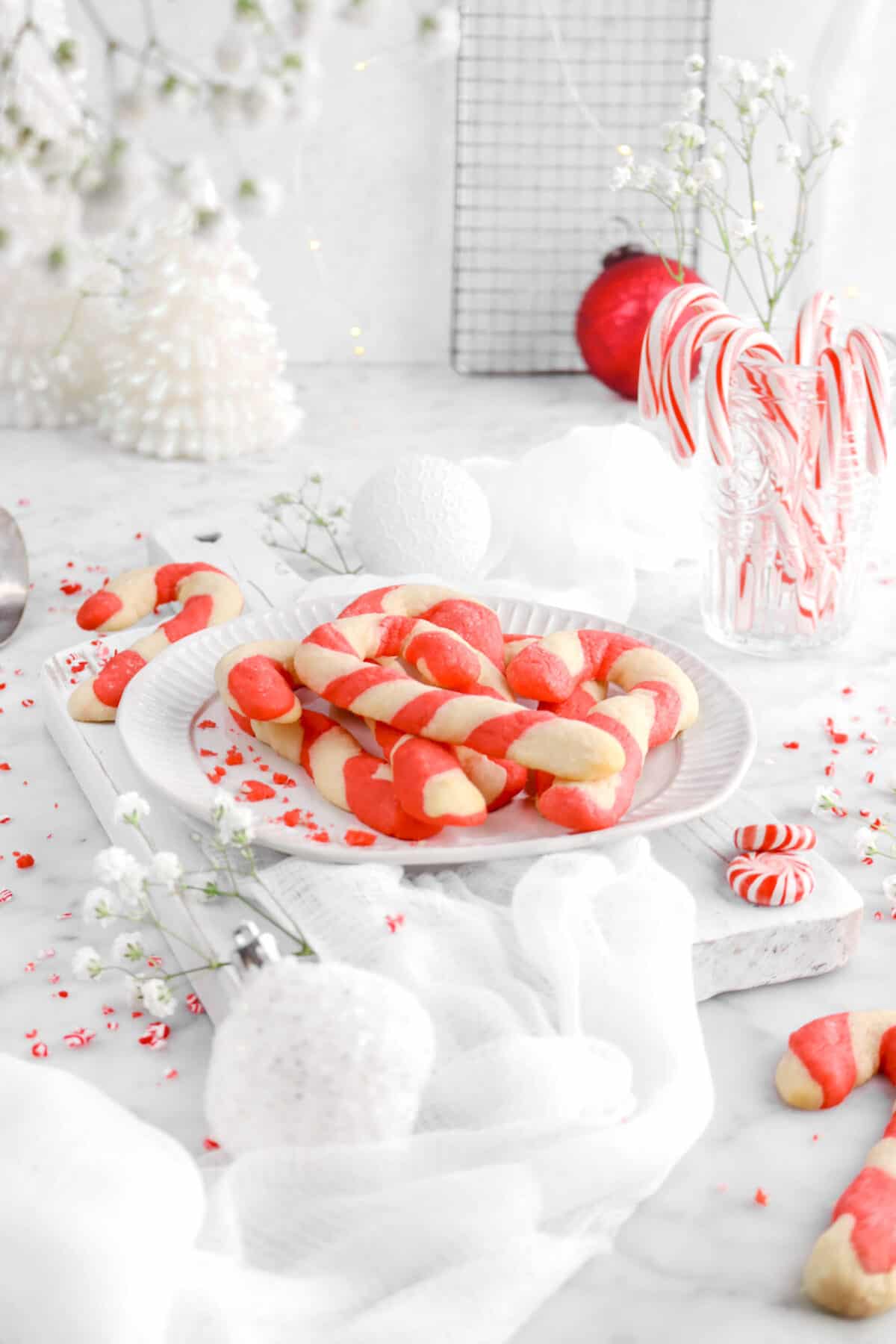 plate full of candy cane cookies with flowers hanging down in front