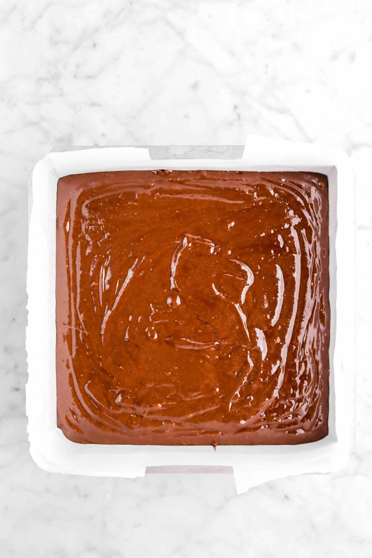 brownie batter in lined cake pan
