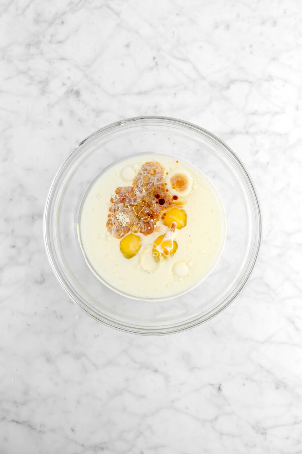 oil, milk, eggs, and vanilla in glass bowl