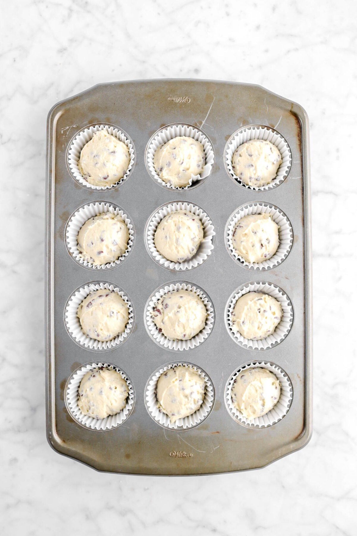 chocolate chip muffin batter in lined muffin pan