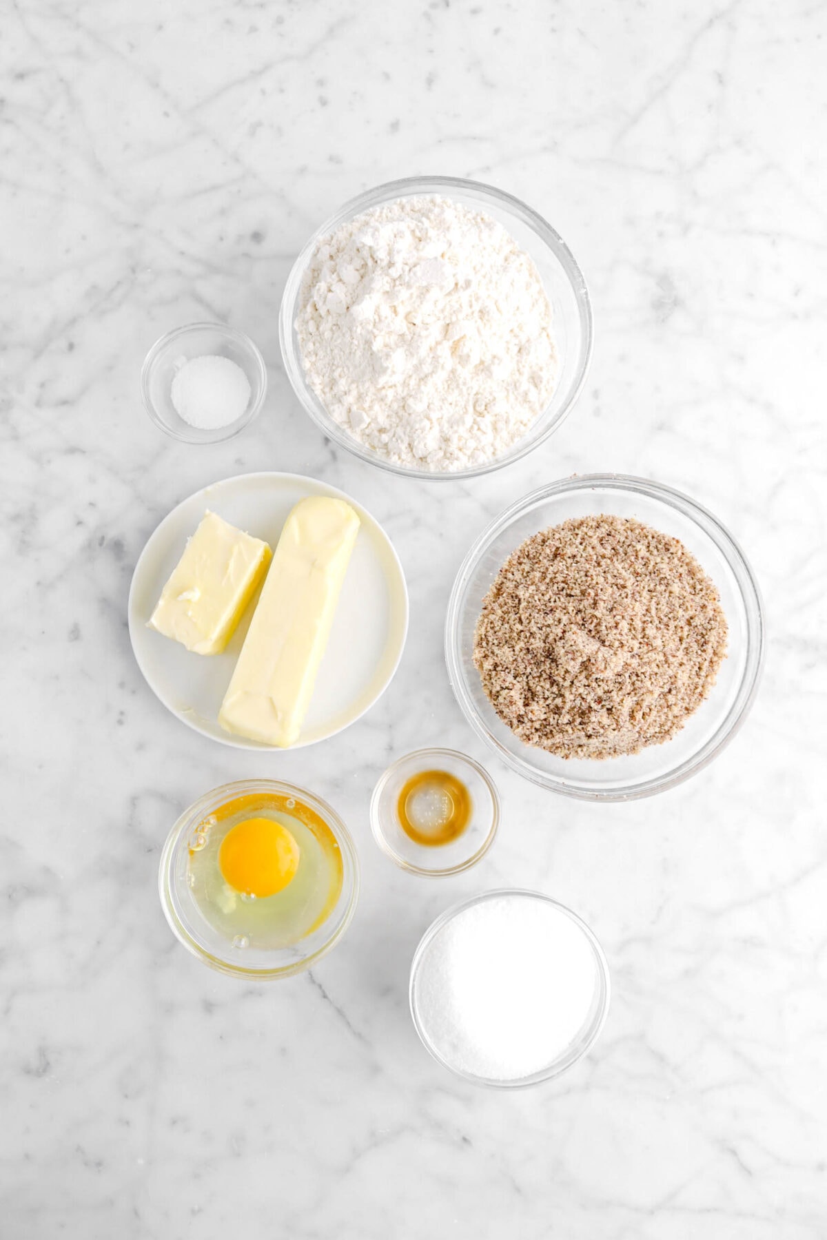 flour, salt, butter, hazelnut flour, vanilla, egg, and sugar on marble surface