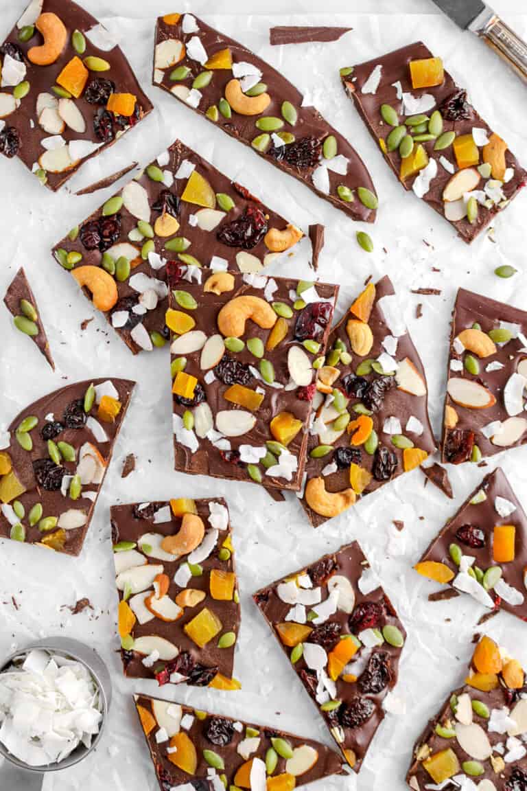 flat lay of chocolate bark on parchment paper with measuring cup full of coconut flakes