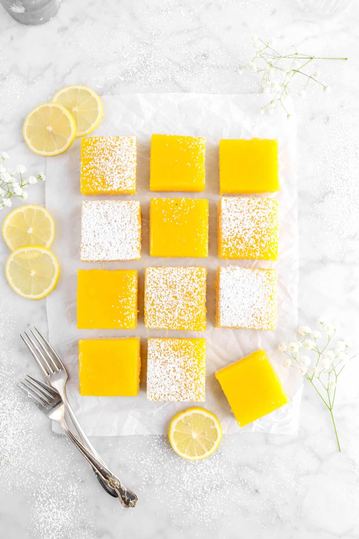 overhead photo of lemon bars on parchment paper with one pulled away