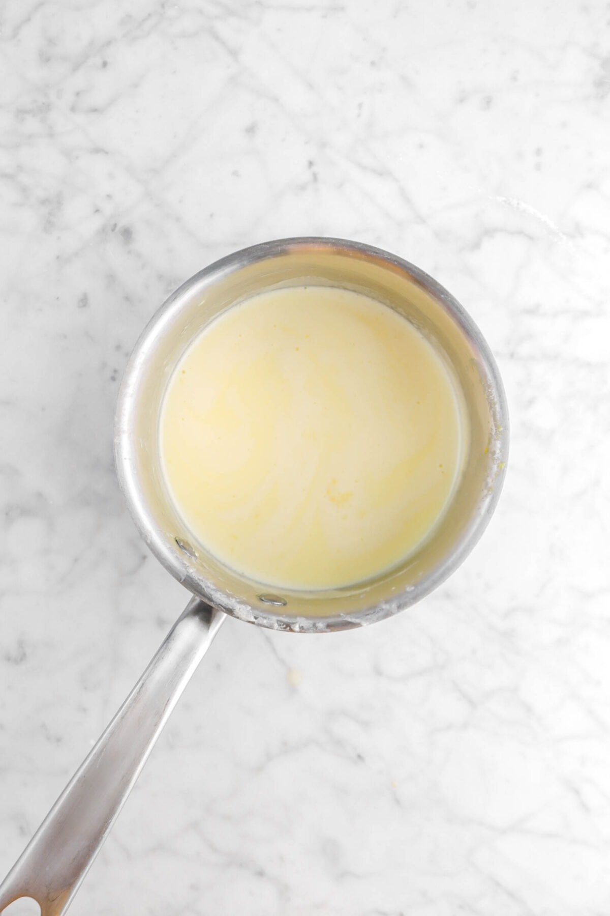 creme anglaise in small pot on marble surface